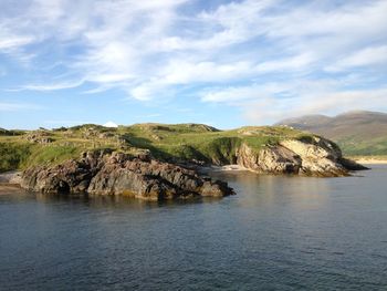 Scenic view of mountain by sea against sky