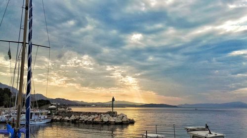 Scenic view of sea against cloudy sky at sunset