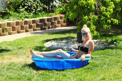 Side view of woman in wading pool on field