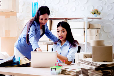 Women discussing over laptop on table