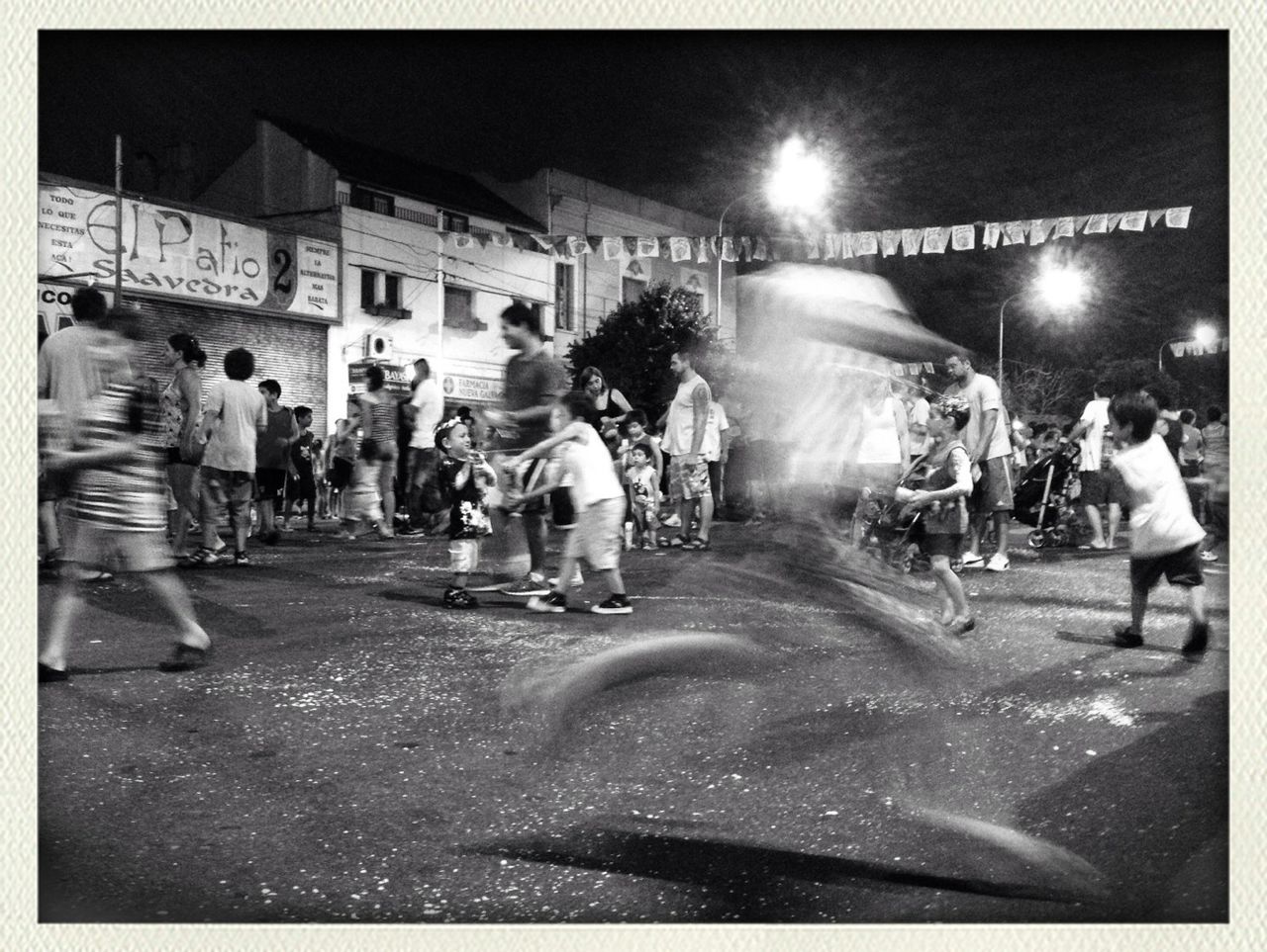 transfer print, night, illuminated, large group of people, men, lifestyles, street, auto post production filter, leisure activity, person, city, crowd, city life, building exterior, walking, full length, road, celebration, architecture