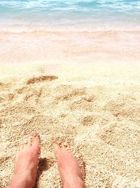 Low section of feet on sand at beach