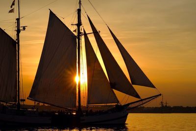 Silhouette sailboat on sea against sky during sunset