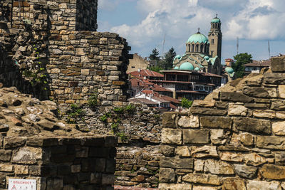 Stone wall of historic building against sky