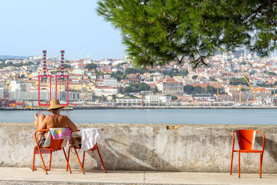 Rear view of woman looking at sea at a red chair