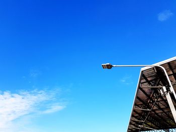 Low angle view of electric pole against blue sky