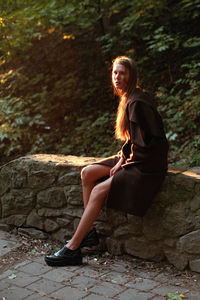 Young woman sitting on tree