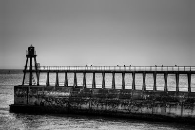 Pier over sea against clear sky