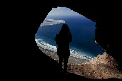 Rear view of silhouette woman looking at sea