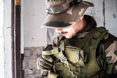 Midsection of man holding hat at camera