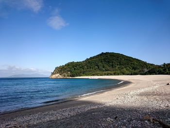 Scenic view of beach against blue sky