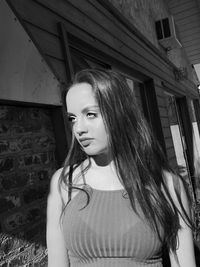 Close-up of young woman standing against wall