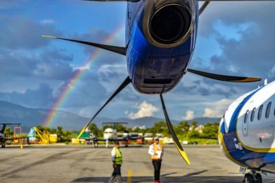 Men standing by airplane against sky