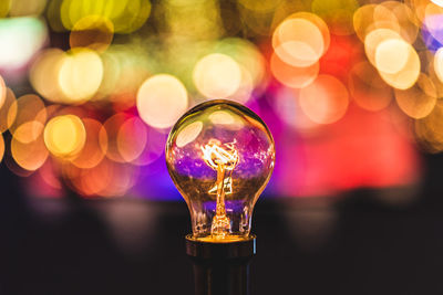 Close-up of illuminated light bulb against bokeh