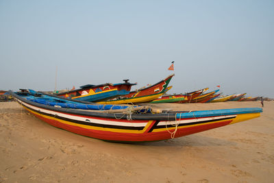 Boat moored on beach against clear sky