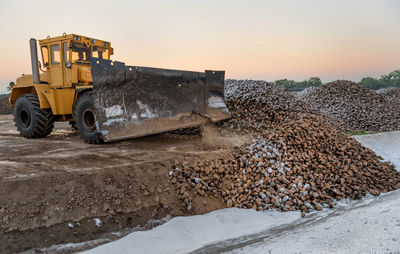 Earth mover at construction site against sky