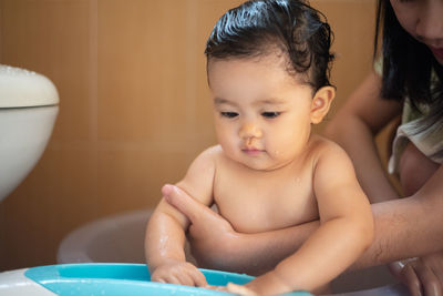 High angle view of shirtless boy looking at camera