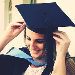 Close-up of smiling young woman wearing mortarboard