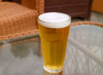 Closeup a glass of mouthwatering chilled beer being served on the table