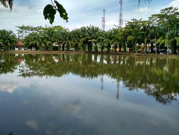 Reflection of trees in swimming pool against sky
