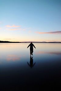 Man on lake against sky