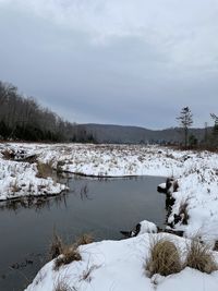 Scenic view of lake against sky during winter