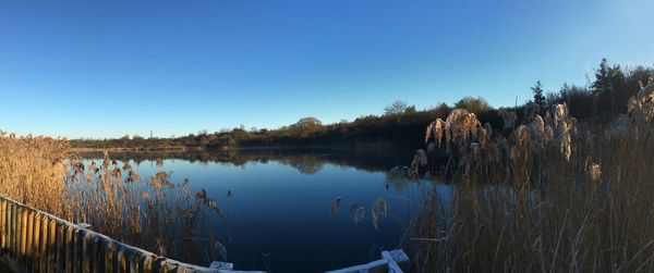 Scenic view of lake against clear blue sky