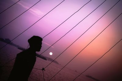 Silhouette person standing against sky during sunset