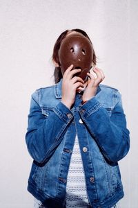 Close-up of young woman standing against wall
