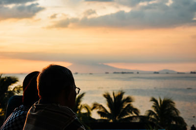 Rear view of woman looking at sea against sky