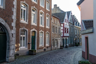 Narrow road with cobblestone pavement and historic buildings in stolberg, eifel, germany