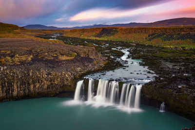 Scenic view of waterfall against sky