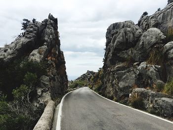 Road amidst rock formation against sky