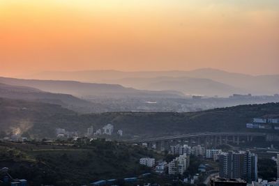 High angle view of buildings in city during sunset