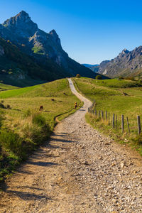 Road leading towards mountain against sky