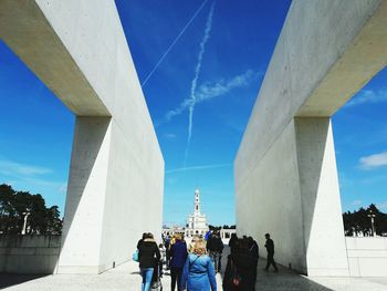 Low angle view of people on bridge against sky