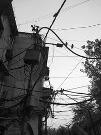 Low angle view of electricity pylon against sky