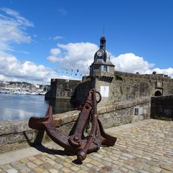 View of old town wall and clock tower  against blue sky and clouds