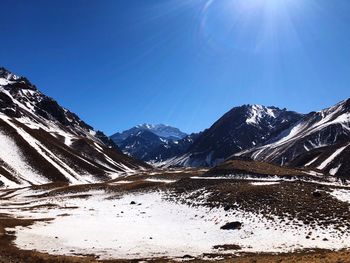 Scenic view of snowcapped mountains against clear blue sky