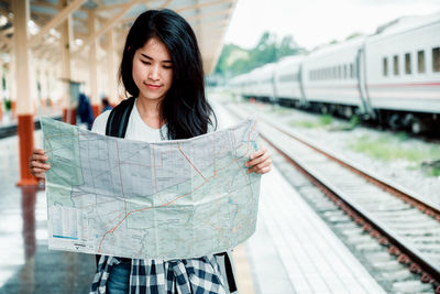 Woman looking away while train on railroad track