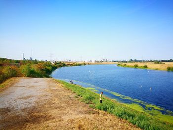 Scenic view of river against clear blue sky