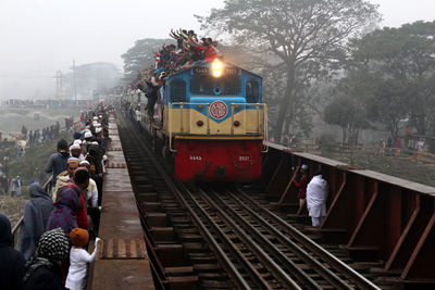 Over crowded train crossing a rail bridge
