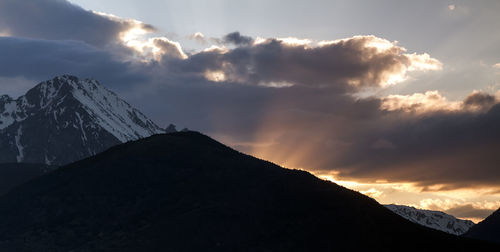 Scenic view of snowcapped mountains against sky during sunset