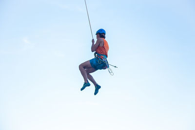 Low angle view of man paragliding against sky