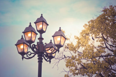 Low angle view of illuminated street light against sky