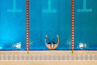 Swimming pool by wall against blue sky