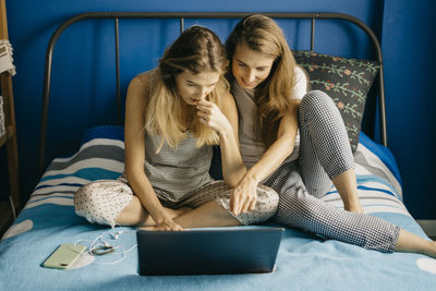 Freelancer woman show her work for sister and watch in laptop