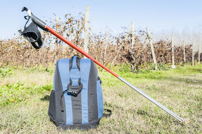 Close-up of backpack and hiking pole on grassy field