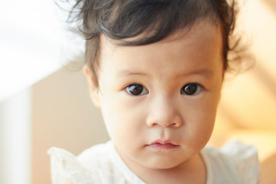 Close-up portrait of cute baby girl at home