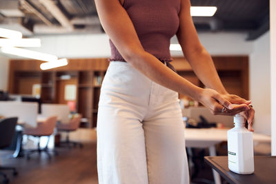 Midsection of woman holding white standing at home